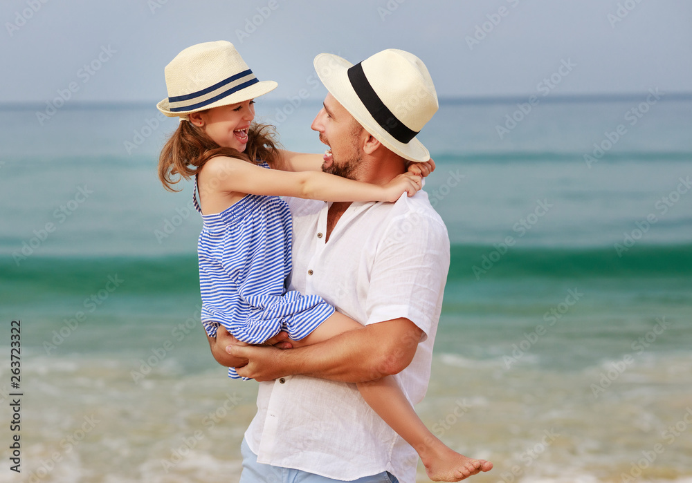 happy family at beach. father and child daughter hug at sea happy family at beach. father and child daughter hug at sea