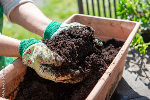 woman with handful of soil in garden