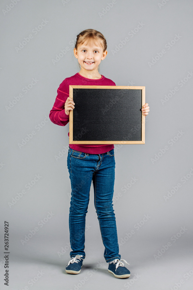 Cute girl holding a blank blackboard with space for text Cute girl holding a blank blackboard with space for text