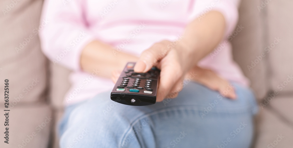 Senior woman using TV remote control on sofa at home Senior woman using TV remote control on sofa at home
