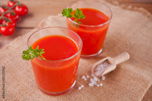 Tomato juice with parsley and salt on the jute napkin