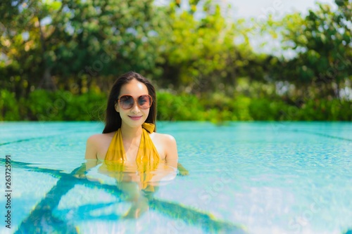 Portrait beautiful young asian woman smile happy relax and leisure in the swimming pool