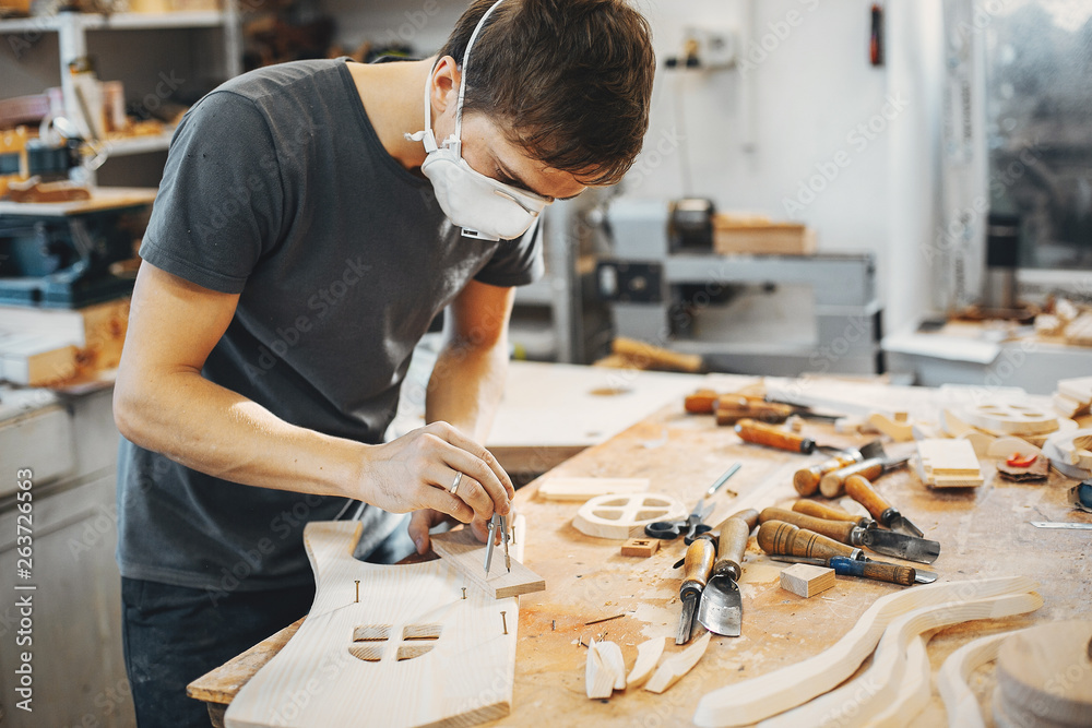 A man carves a tree. The carpenter works in a studio. An engineer provides a tree shape A man carves a tree. The carpenter works in a studio. An engineer provides a tree shape