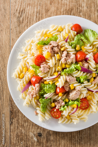 Pasta salad with vegetables and tuna on wooden table. Top view
