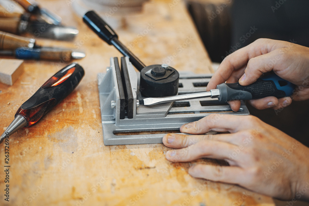 A man carves a tree. The carpenter works with screwdriver in a studio. An engineer provides a tree shape A man carves a tree. The carpenter works with screwdriver in a studio. An engineer provides a tree shape