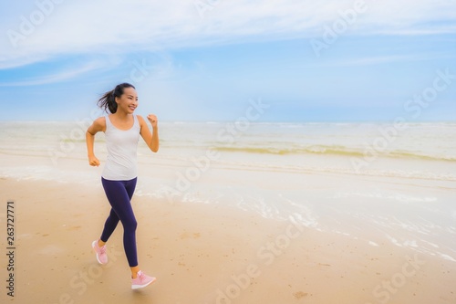 Portrait beautiful young sport asian woman exercise by run and jogging on the outdoor nature beach and sea