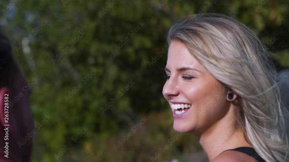 Closeup of Young Blonde Woman Laughing and Brushing Her Hair on Cliffs Edge Closeup of Young Blonde Woman Laughing and Brushing Her Hair on Cliffs Edge