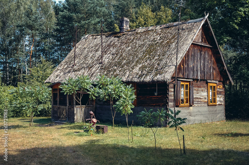 Old wooden house with thatched roof in a small village in Wegrow County in Masovian Voivodeship of Poland