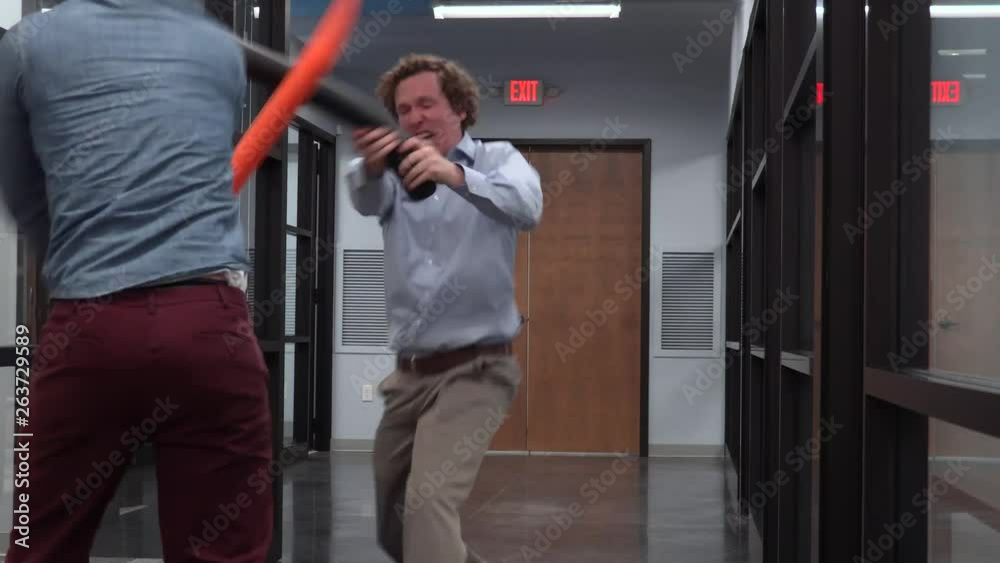 Two Office Employees Having Fun in the Workplace by Having a Fake Sword Fight. Two Office Employees Having Fun in the Workplace by Having a Fake Sword Fight.