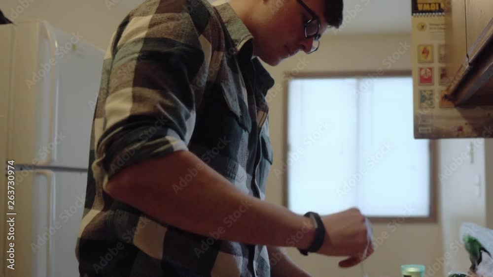 Person stirring food in kitchen. Slow pan to the right. Shallow depth of field. 24 fps. Person stirring food in kitchen. Slow pan to the right. Shallow depth of field. 24 fps.