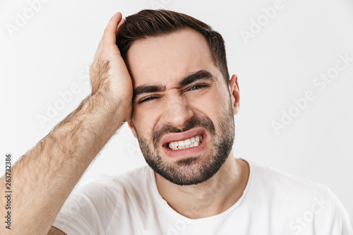 Upset man wearing blank t-shirt standing isolated