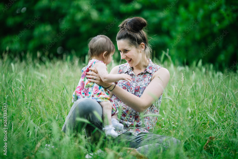 Mother and daughter playing in the grass Mother and daughter playing in the grass