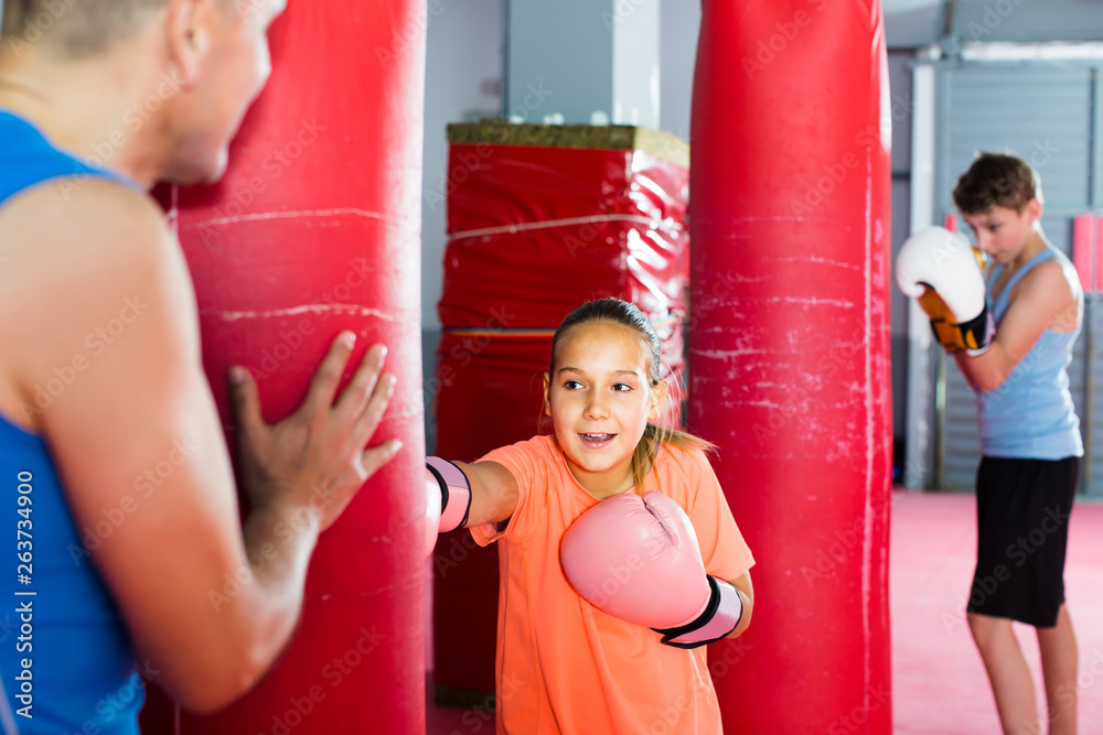 Teens teach a combination of blows on a punching bag