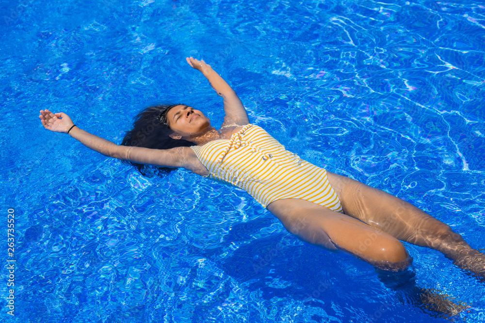 Young indianwoman floating in the pool