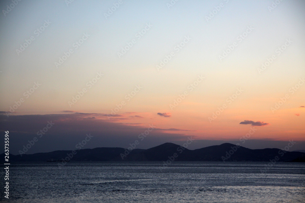 Sunset or sunrise on the sea and mountains in the background. Bright sky. Beautiful seascape. Sunset or sunrise on the sea and mountains in the background. Bright sky. Beautiful seascape.