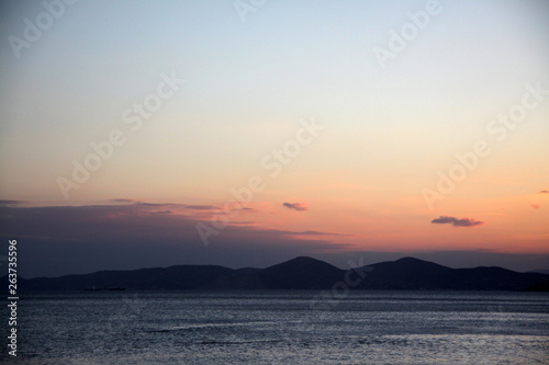 Sunset or sunrise on the sea and mountains in the background. Bright sky. Beautiful seascape.