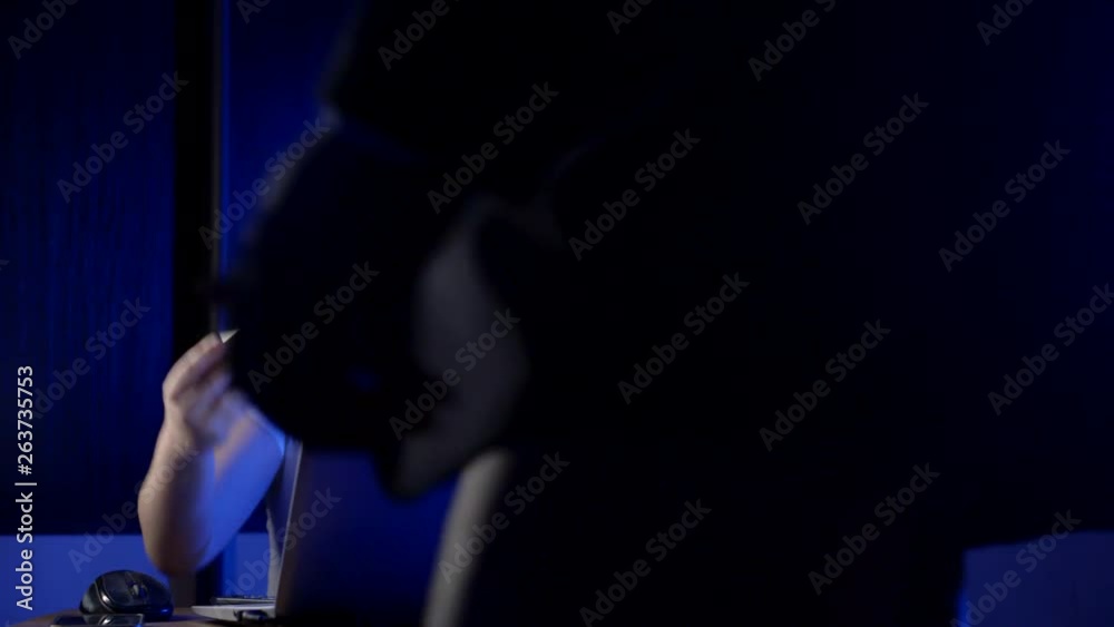 A little girl with two tails on her head is sitting at a laptop in the dark and her dad comes up in a suit, picks up his phone from the table and leaves. A little girl with two tails on her head is sitting at a laptop in the dark and her dad comes up in a suit, picks up his phone from the table and leaves.
