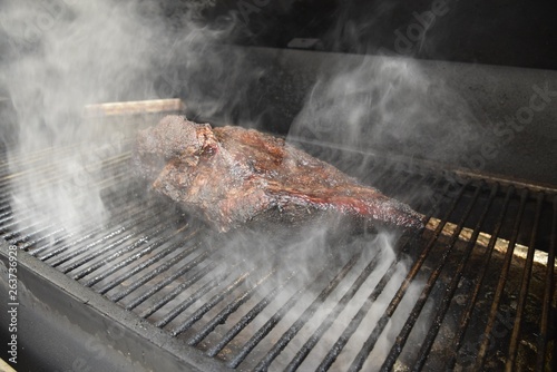 beef brisket smoking on grill