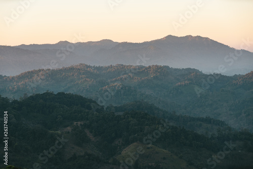 Layers of mountain with sunlight and fog in the evening in the Akha village of Maejantai on the hill in Chiang Mai, Thailand.