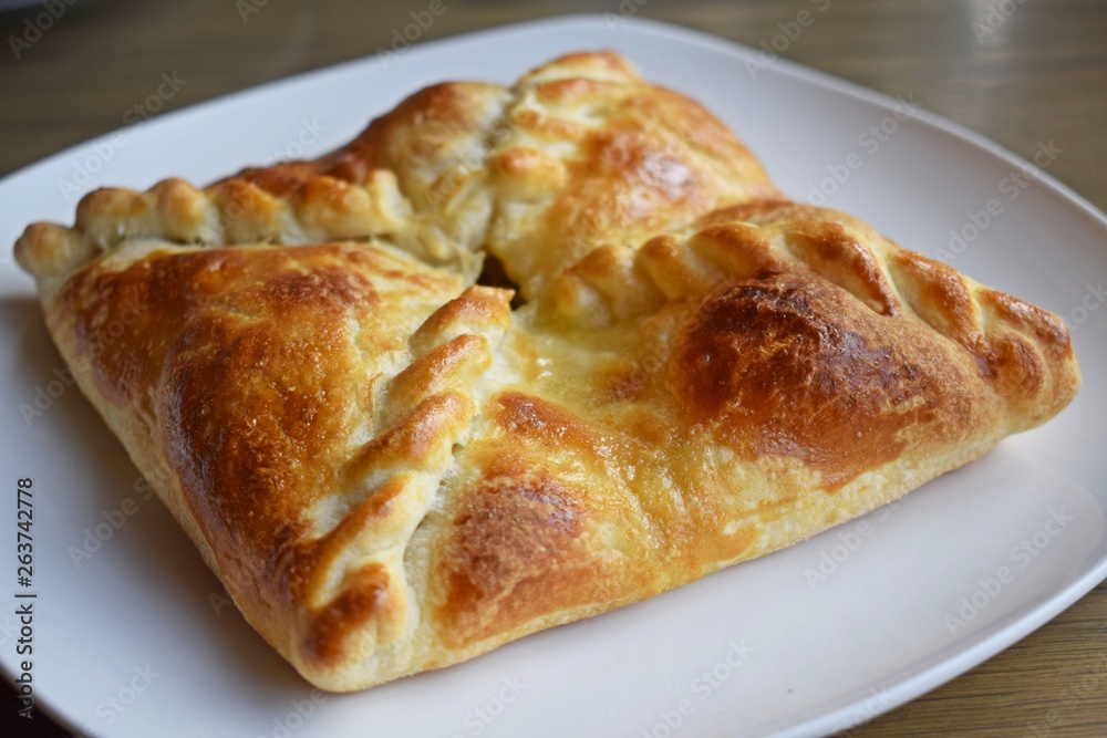 Khachapuri with vegetables and cheese on a white plate. Khachapuri with vegetables and cheese on a white plate.