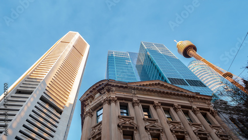 Tall business buildings and Sydney Tower Eye rising towards blue sky