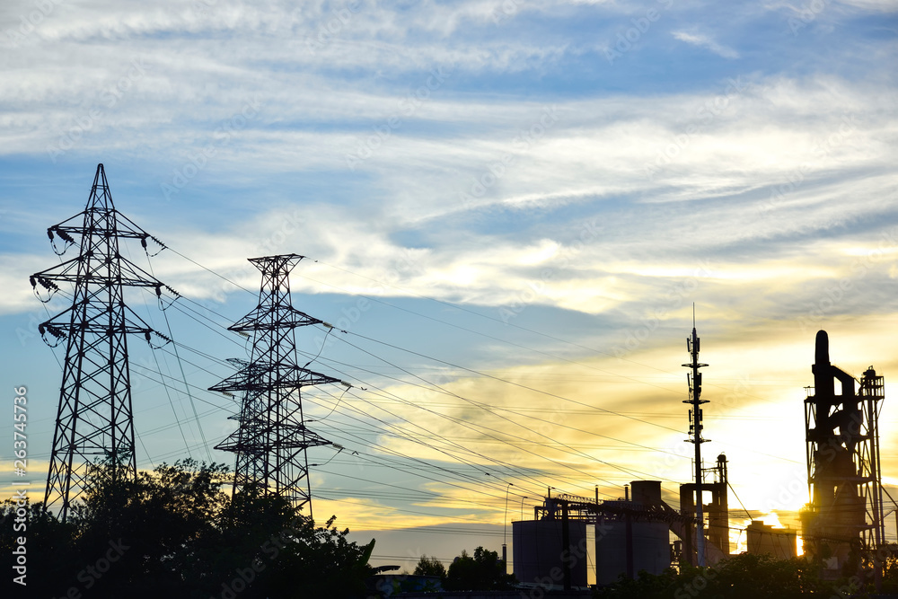 Oil refineries and high voltage towers at sunrise and sunset