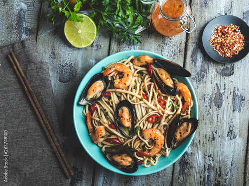 Noodles with shrimp and mussels , spice , on the plate. Closeup. Chinese/Japanese/Asian noodles