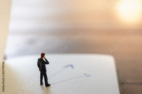 Business, strategy, Planning and job concept. Close up of businessman miniature figures standing on notebook with hand writing arrows .
