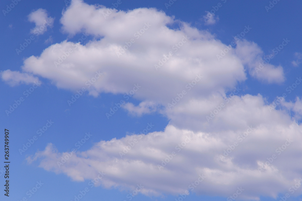 Fototapeta premium Blue sky background with white clouds on a sunny day. Nature concept. Horizontal, plenty of space for text.