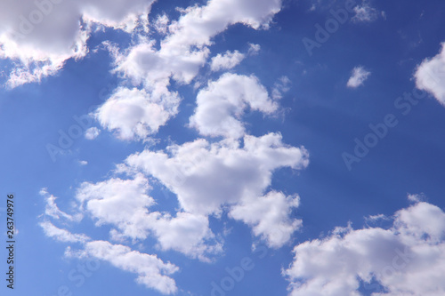 Blue sky background with white clouds on a sunny day. Nature concept. Horizontal  plenty of space for text.
