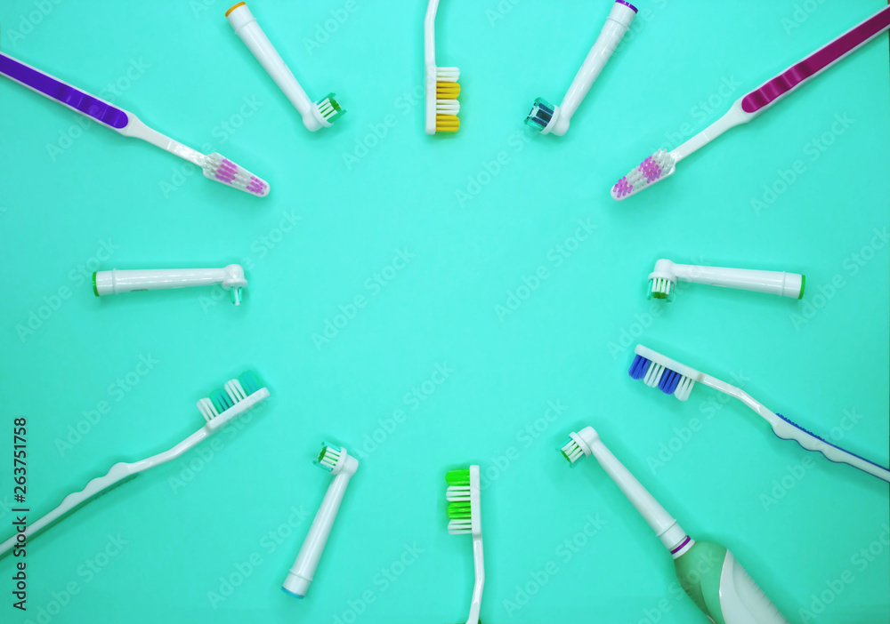 multicolored toothbrushes on a turquoise background with copy space. Flat lay. Top view.