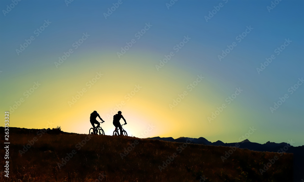Silhouette of two mountain bike riders at sunset