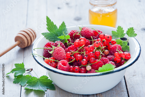 Fresh organic Red berries in a white enamel bowl