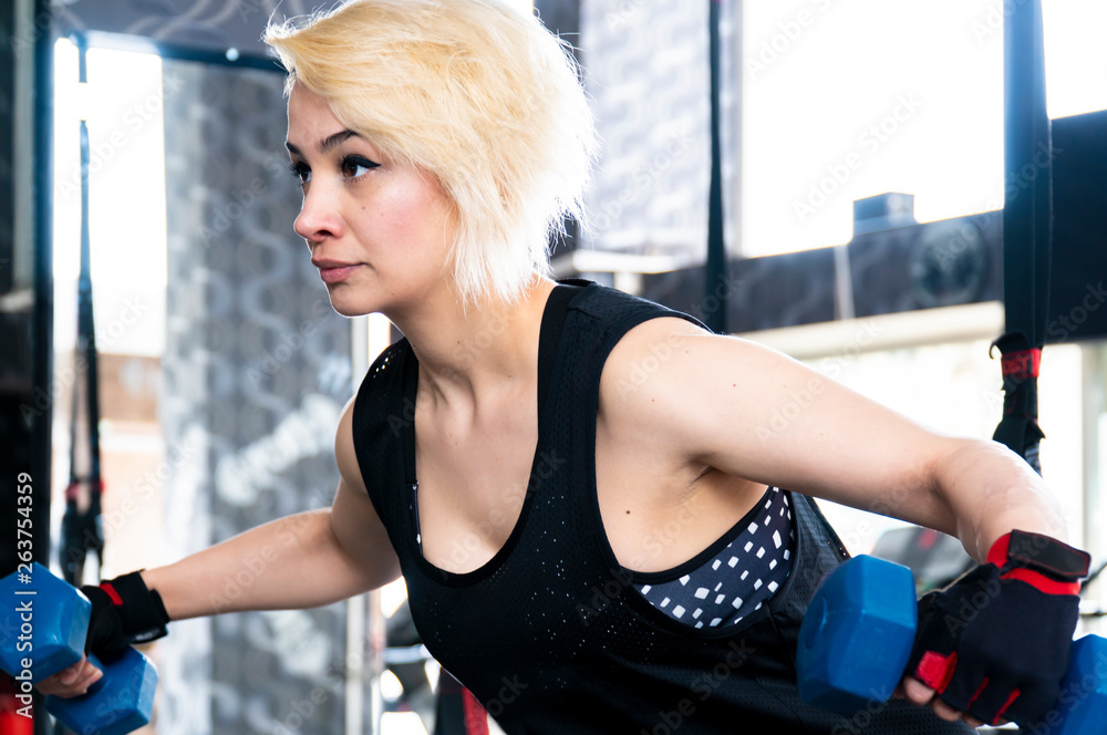 Obraz premium Beautiful blonde girl working at the gym center