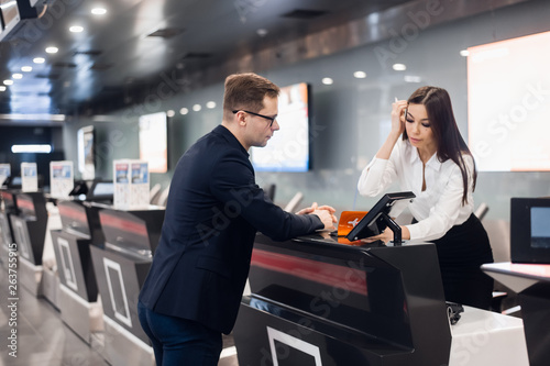 Staff At Airport Check In Desk Handing Ticket To Businessman