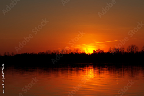 Sunset on the lake. Beautiful red sky. light game © charmphoto