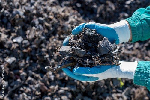 Close up of man holding pieces of shredded tires  photo