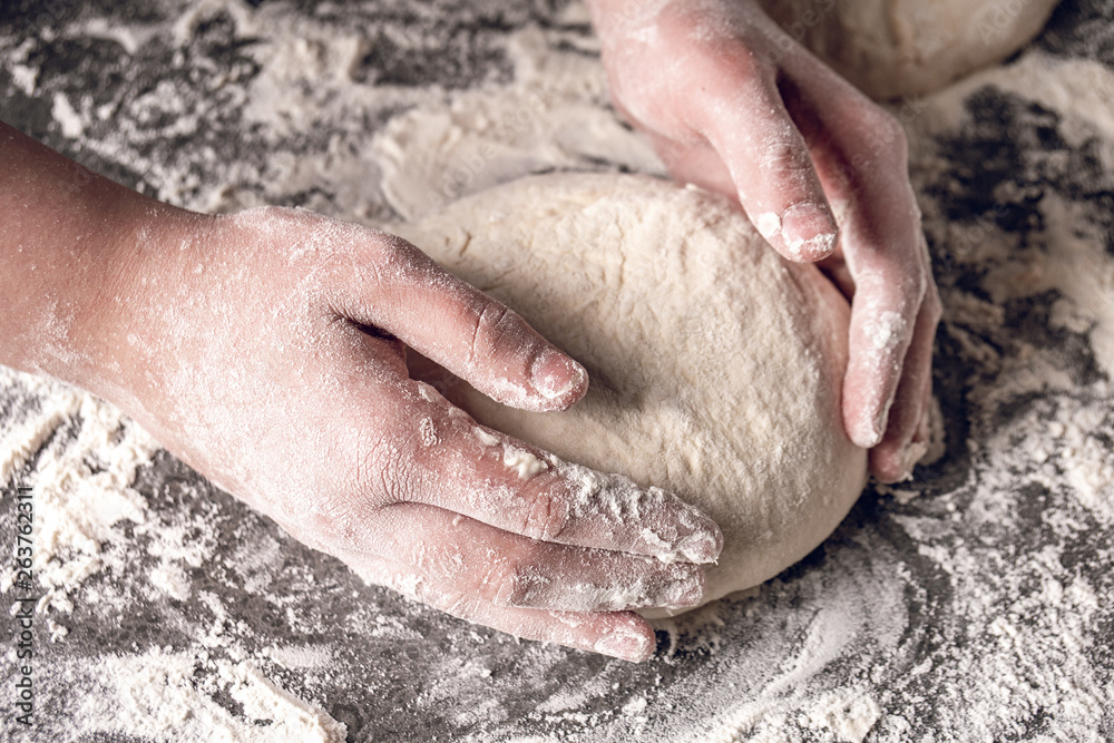 Making dough by female hands at bakery