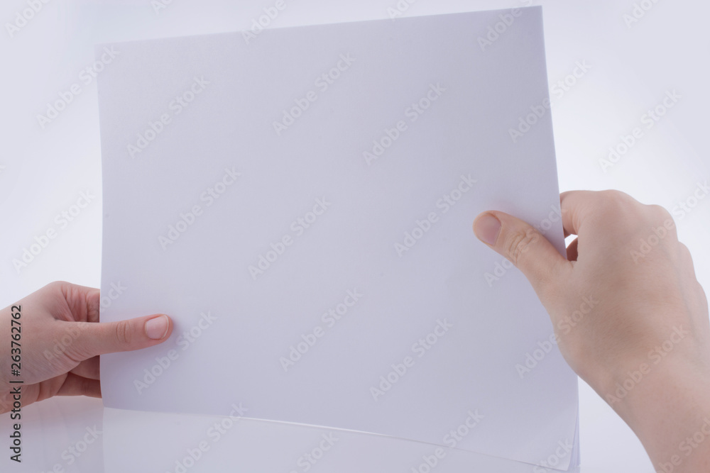 Hand holding a white blank sheet of paper Stock Photo | Adobe Stock