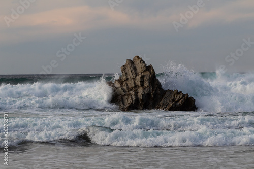 rock in the sea, which is hit by the waves. On the beach of Atxabiribil in Sopelana