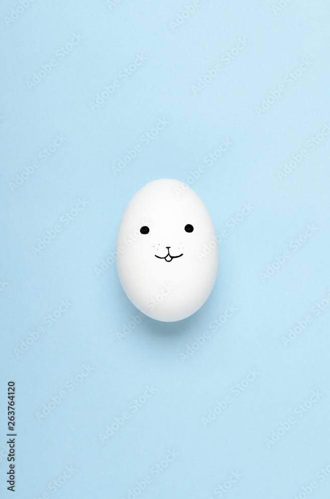 Kawaii faces on white eggs on a blue background. Cartoons, decoration food for children. Top view, flat lay.