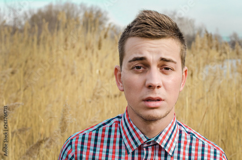 Smiling young guy in nature.