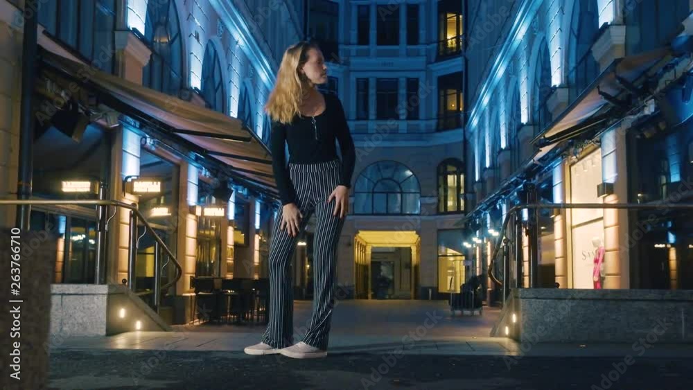 Woman walking alone at night in the city, checks behind her for a noise she hears, 60 fps. Woman walking alone at night in the city, checks behind her for a noise she hears, 60 fps.