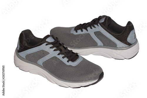 Pair of gray sport sneakers on the side on a white isolated background.