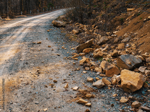 Road broken by a mountain avalanche of stones