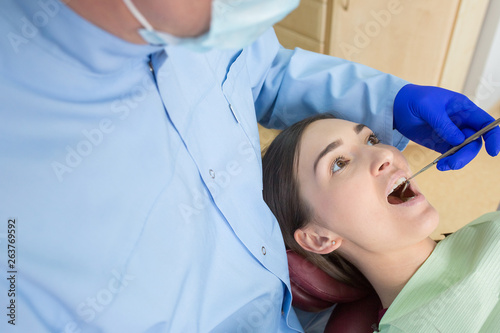 Young woman sits in a dental chair as a patient. People health care  dentistry  medicine concept. Doctor and patient. Teeth dentist with patient in hospital
