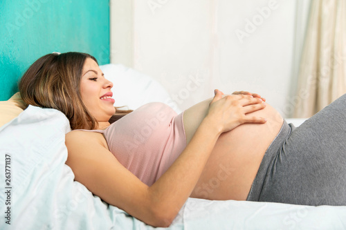 Pregnat woman in the bedroom.