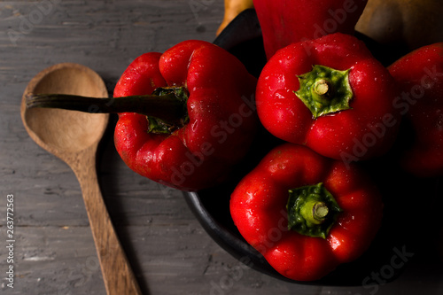 STILL LIFE OF RED PEPPERS ON A RUSTIC WOODEN TABLE photo