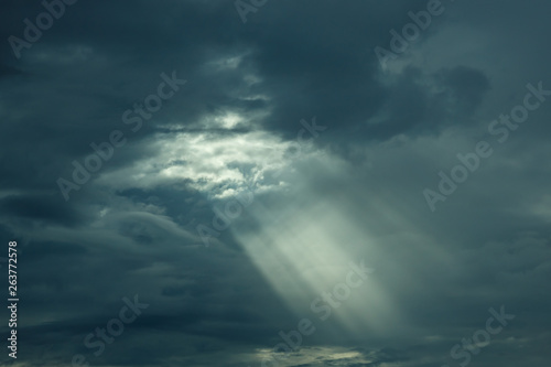 The sun's rays at sunset making their way through the clouds.