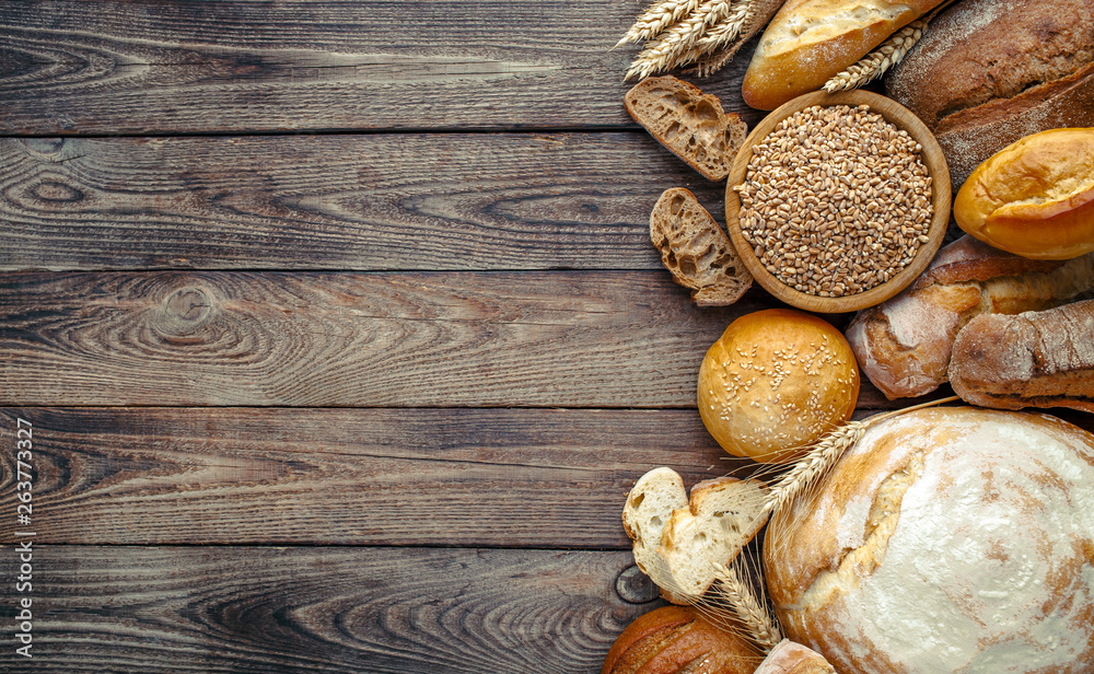 Assortment of baked bread on wooden table background,top view